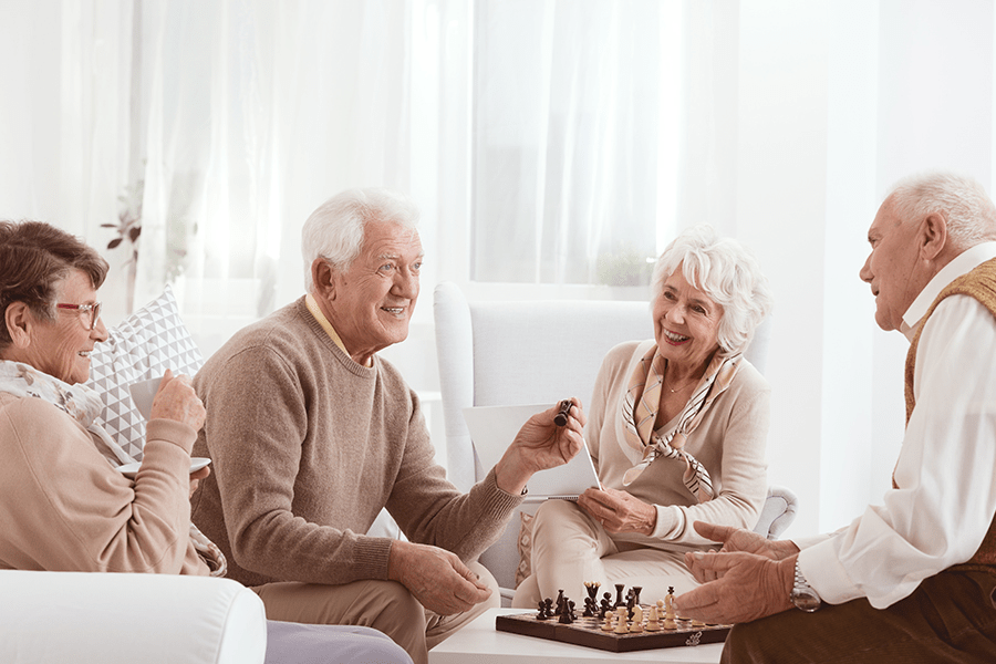A group of joyful seniors engaged in a friendly game of chess, sharing laughter and camaraderie in a lively social setting