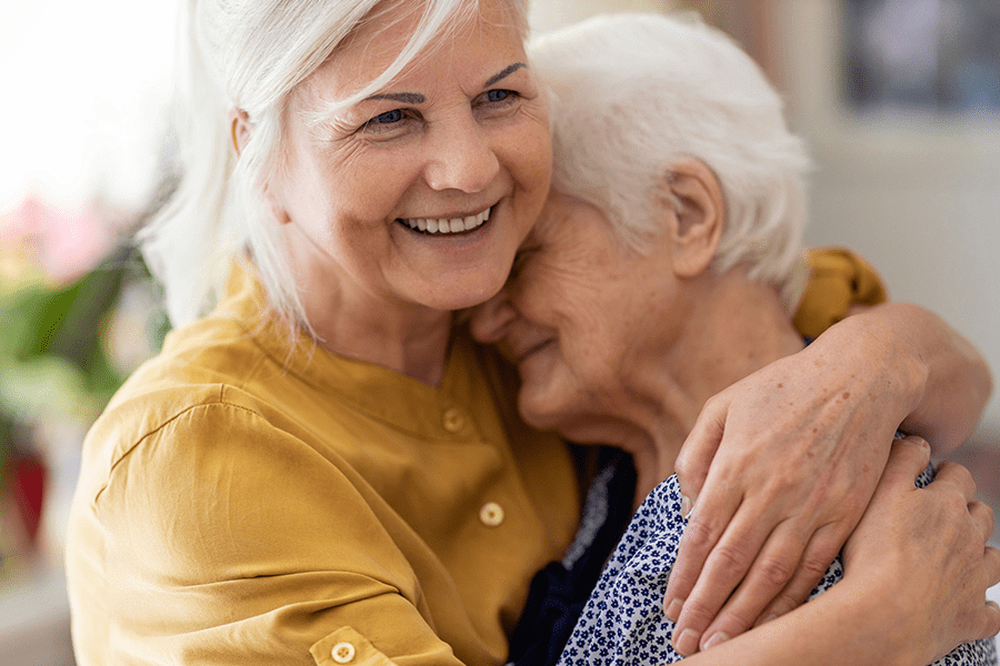 A woman enjoying quality time with her elderly mother during family visits at an independent living retirement community