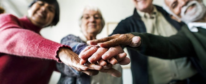 Group of senior adults hands together representing the resident council.