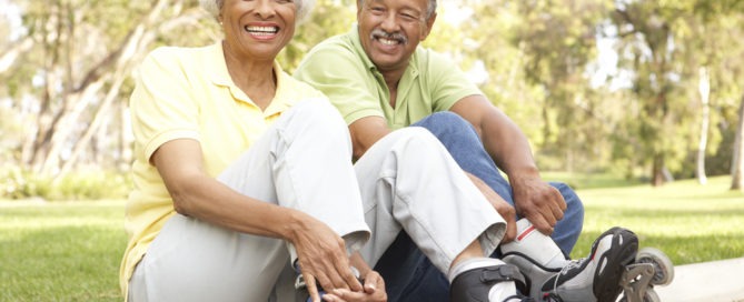 Senior Couple Putting On In Line Skates In Park