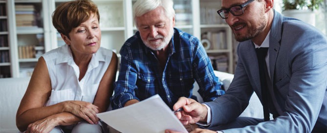 Senior couple inquiring about lifecare planning from an insurance agent.