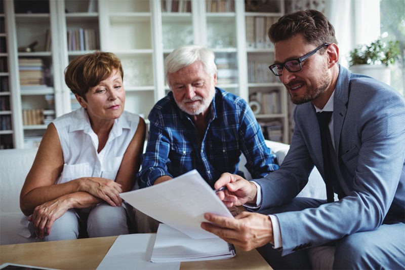 Senior couple inquiring about lifecare planning from an insurance agent.