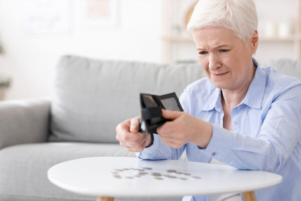 Senior lady counting coins on the table