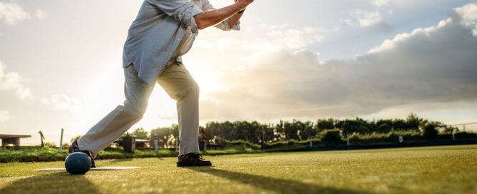 Senior man playing bocce ball as his outdoor exercise.