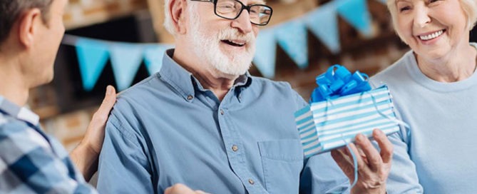 Senior man receiving a gift concept image for what is a good retirement gift for a man.