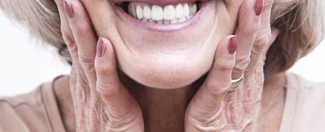 Senior woman wearing new dentures concept image for how long does it take to get used to dentures.