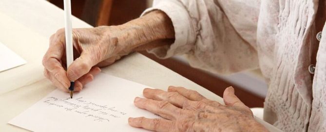 Senior woman is thinking of what to write on a retirement card.